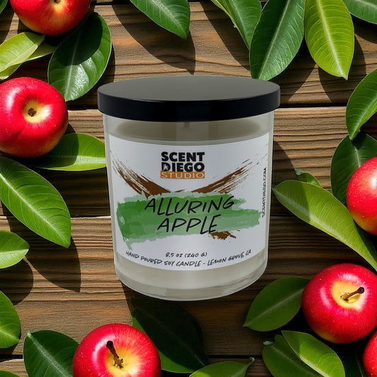Candle labeled 'Alluring Apple' by Scent Diego Studio with apples and leaves on a wooden background