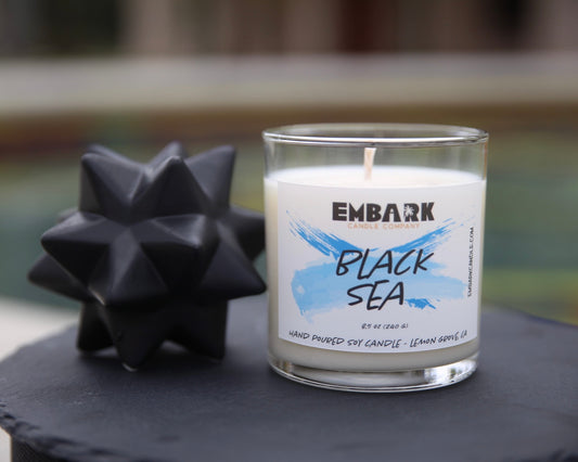 Black Sea soy candle with no lid on black ledge
